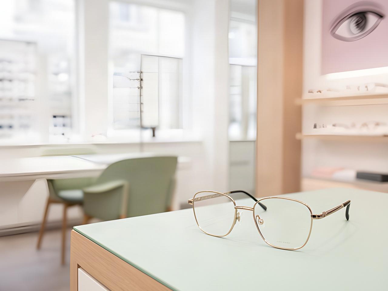 Nahaufnahme einer Brille auf einem Beratungstisch in einem hellen Optikgeschäft in Genf